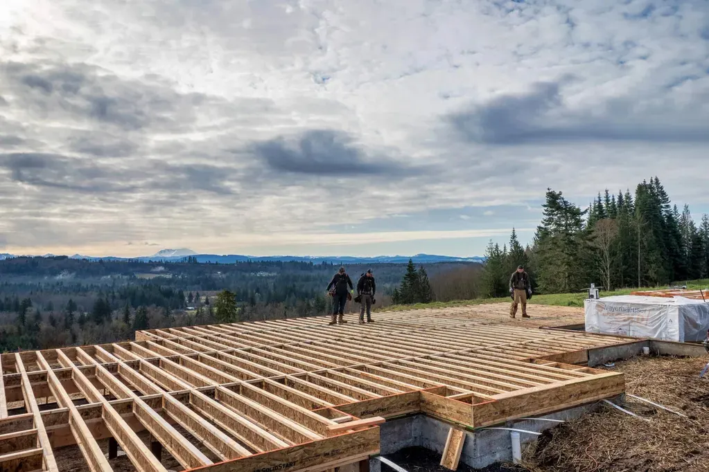 Doyle Construction crew standing on the wooden framing of a custom home build in rural Thurston County