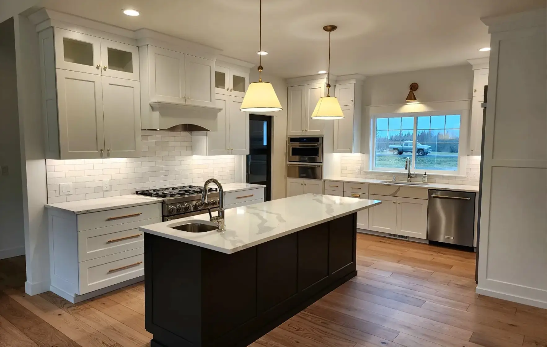 White kitchen with black island and pendant lighting in the Birchfield custom home