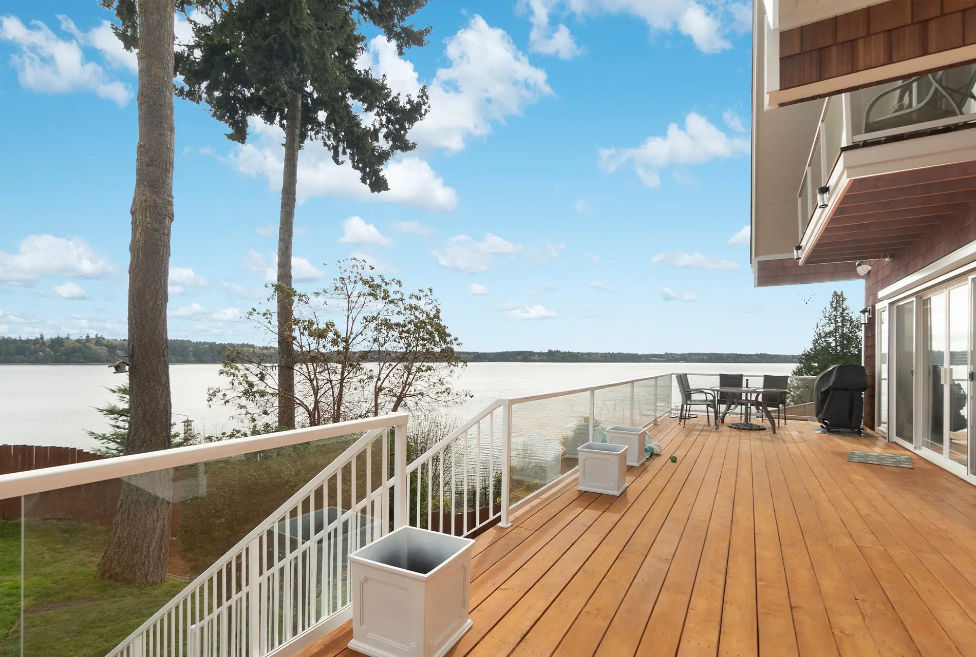 Wooden deck with white railings on a custom home built by Doyle Construction