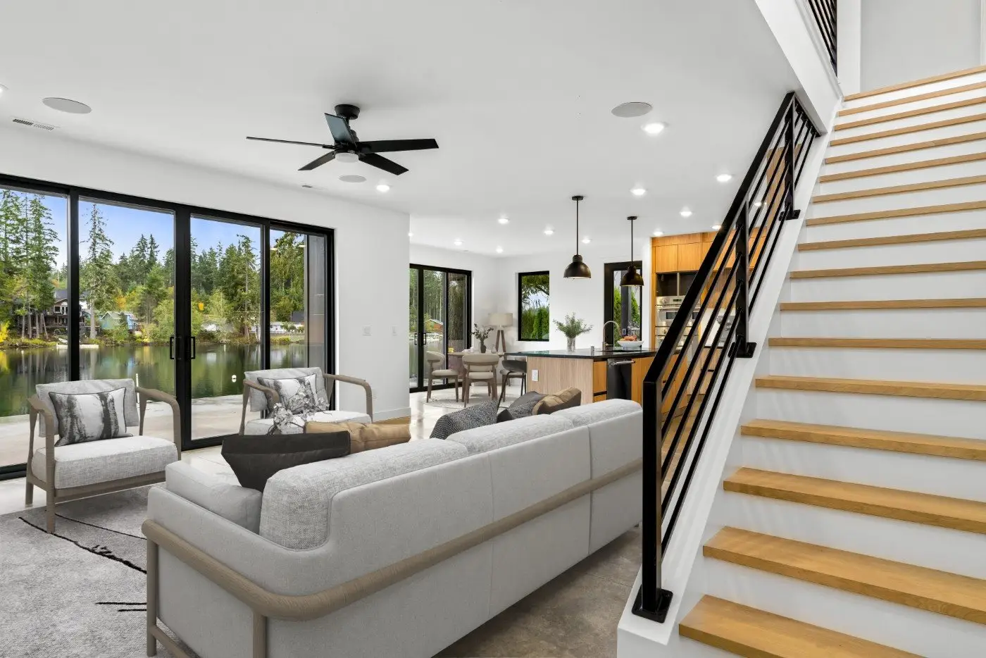 Open living room with lake views through floor-to-ceiling glass at the Spencer Lake Custom home