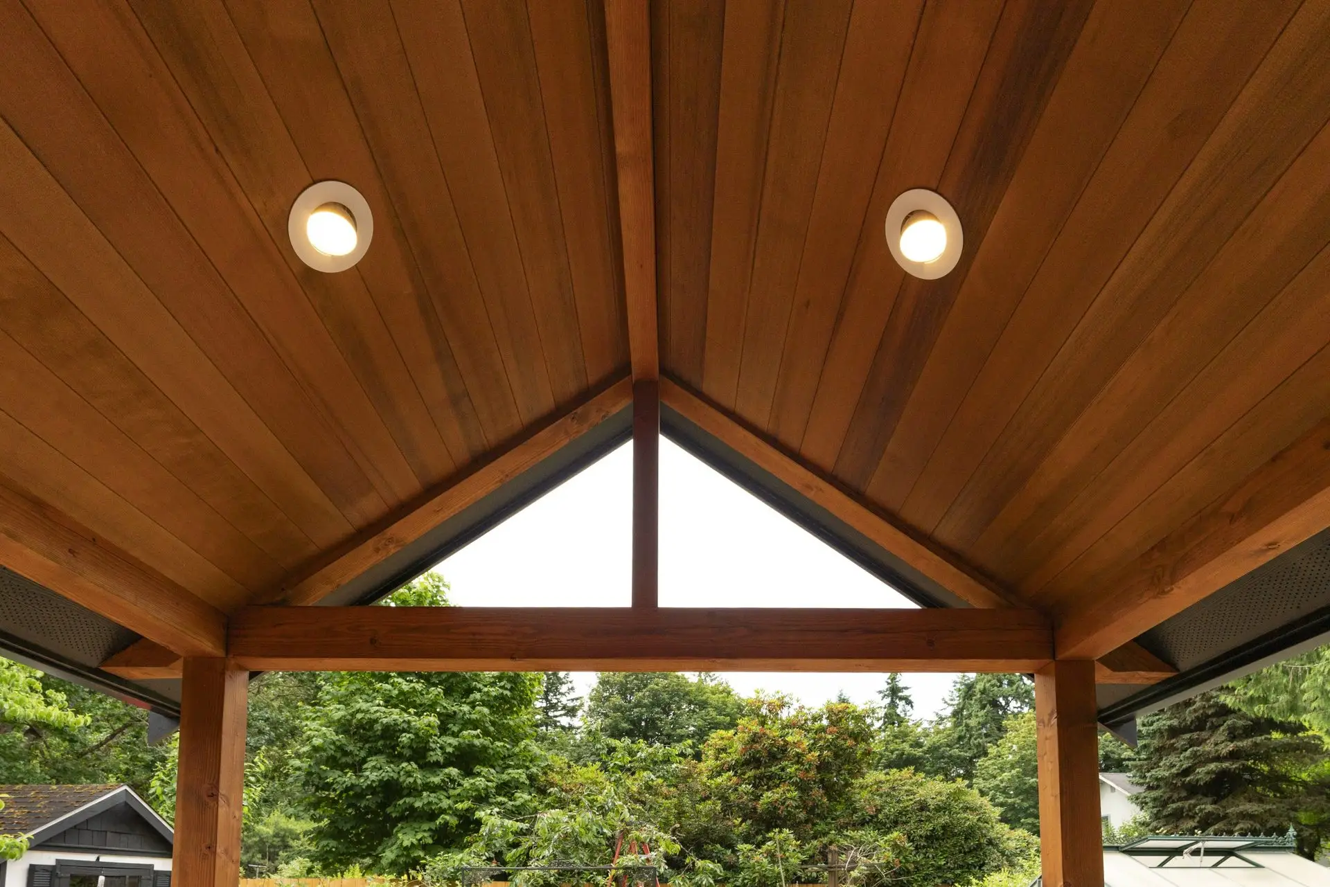 Vaulted tongue-and-groove wood porch ceiling with recessed lights and a triangular window at the Westside Olympia Remodel